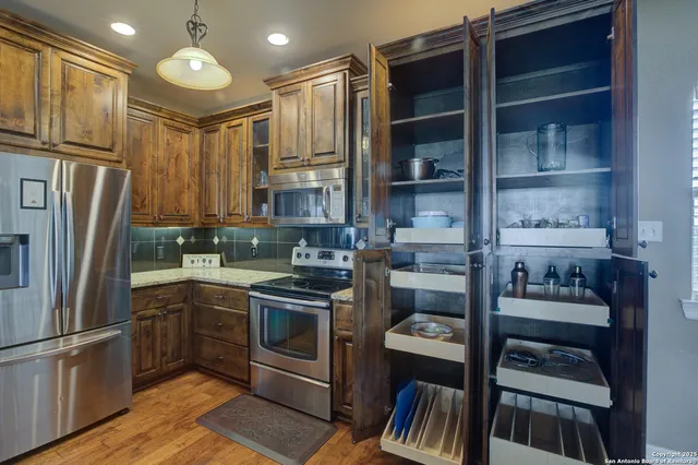 a kitchen with stainless steel appliances granite countertop a refrigerator and a stove top oven