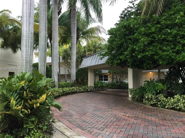 a front view of a house with a yard and potted plants