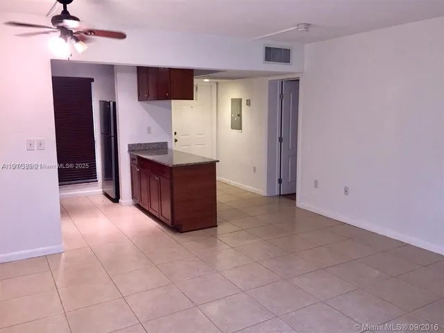 a view of kitchen with refrigerator and cabinets