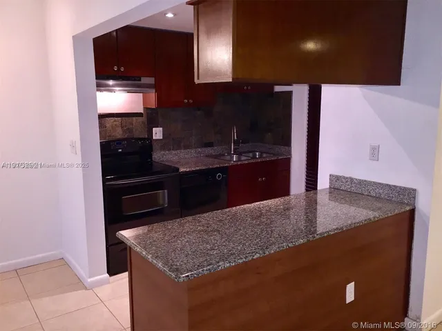 a kitchen with stainless steel appliances granite countertop a sink and a stove