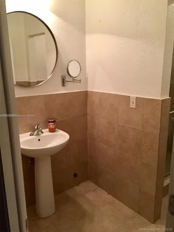 a bathroom with a sink a toilet and a mirror