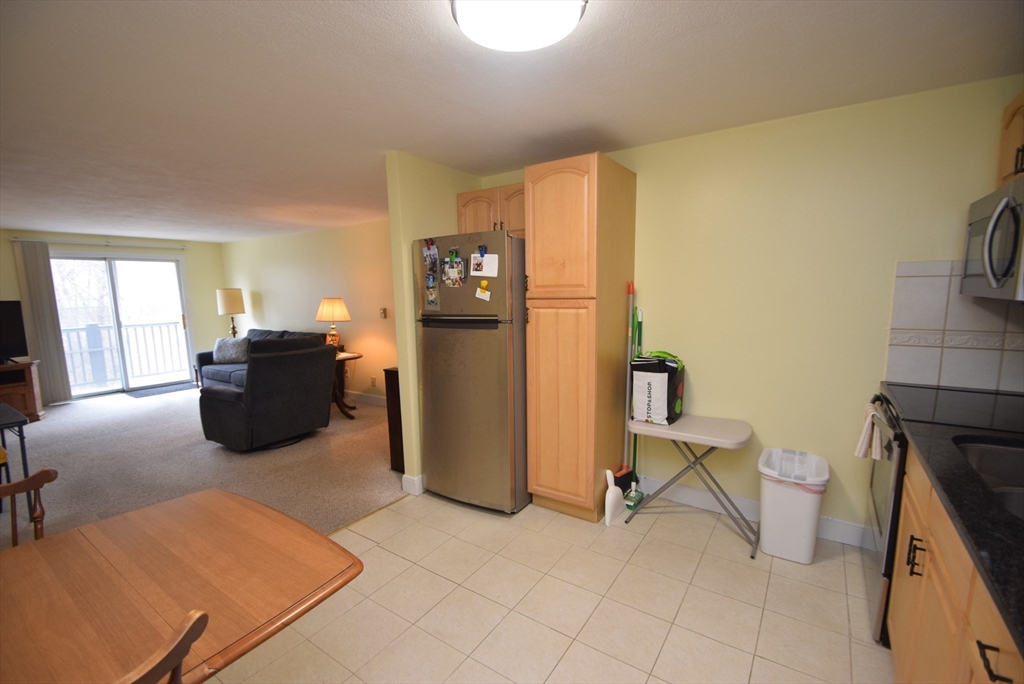 13 Walker Road, Unit 12 North Andover, MA 01845 - Photo 8 of 18 a living room with furniture a flat screen tv and a refrigerator