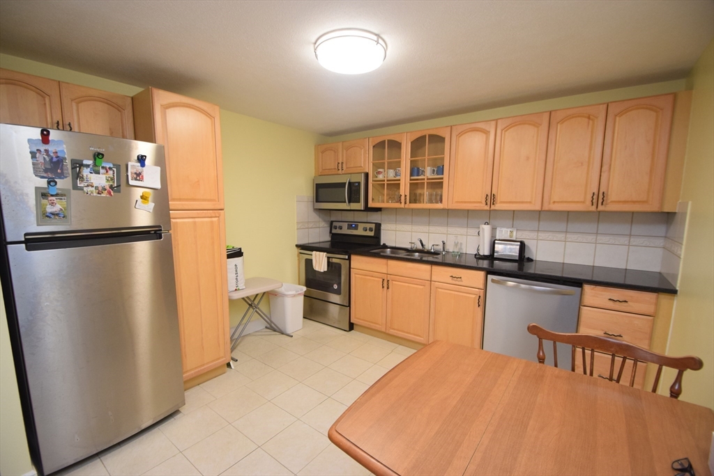 13 Walker Road, Unit 12 North Andover, MA 01845 - Photo 9 of 18 a kitchen with stainless steel appliances granite countertop a refrigerator sink and cabinets