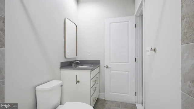a bathroom with a granite countertop sink toilet and mirror