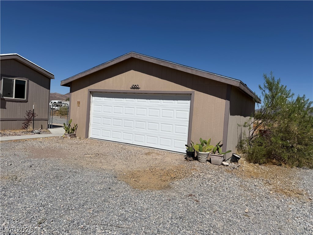 4360 Retread Road Pahrump, NV 89048 - Photo 13 of 19 Detached garage structure offers secure vehicle storage and work space under a clear blue sky.