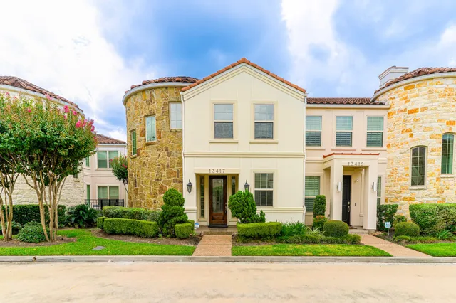front view of a brick house with a yard