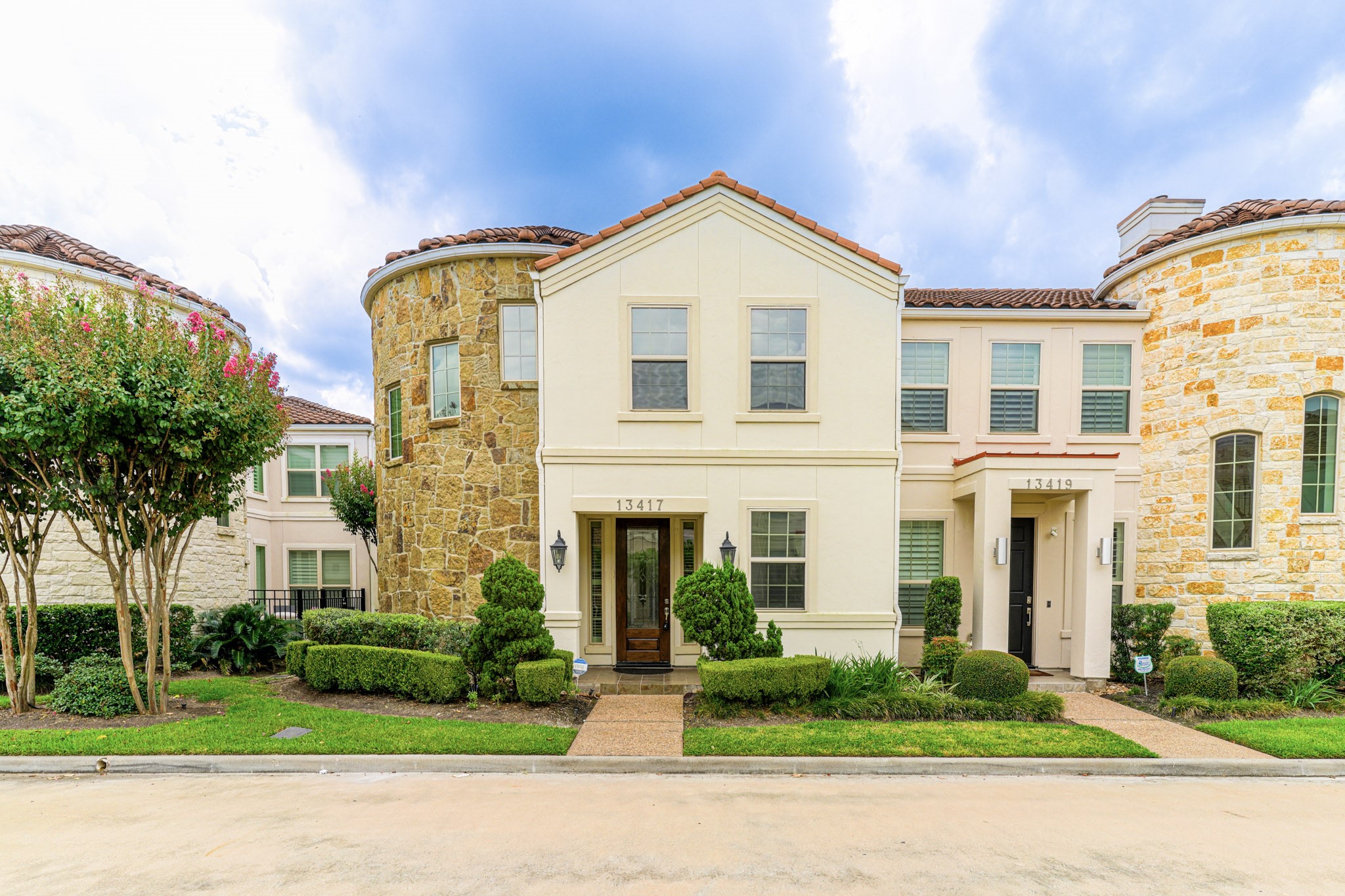 front view of a brick house with a yard