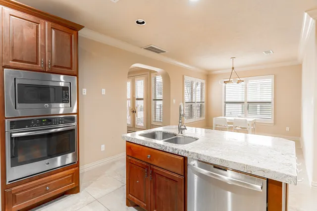 a kitchen with granite countertop a sink and stainless steel appliances