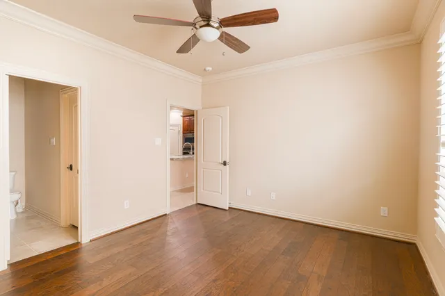 an empty room with wooden floor closet and windows