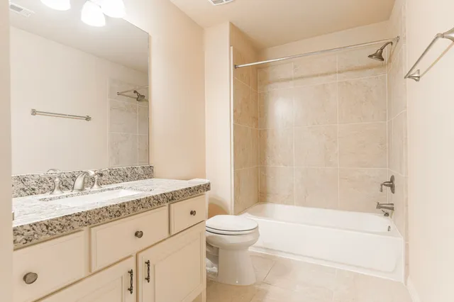 a bathroom with a granite countertop sink a toilet and a bathtub