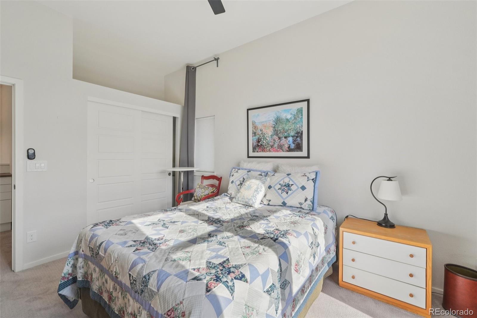 2005 West 66th Avenue Denver, CO 80221 - Photo 31 of 47 a bedroom with a bed and a lamp on table