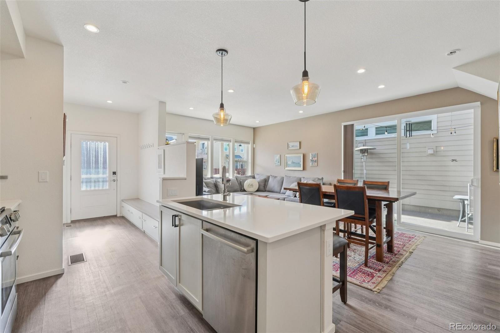 2005 West 66th Avenue Denver, CO 80221 - Photo 4 of 47 a open kitchen with stainless steel appliances granite countertop a dining table chairs stove and white cabinets