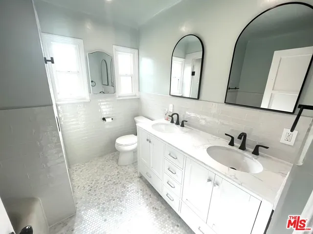 a spacious bathroom with 2 sink and a mirror