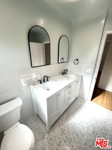 a bathroom with a sink a toilet and mirror