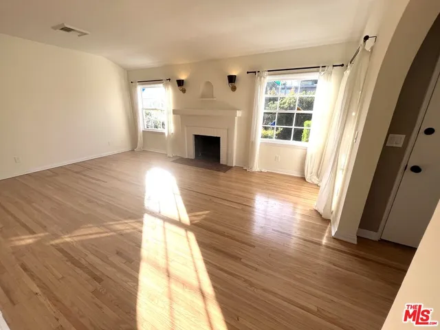 a view of empty room with wooden floor and fireplace