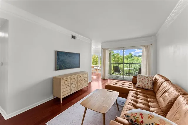 a living room with furniture a window and a flat screen tv