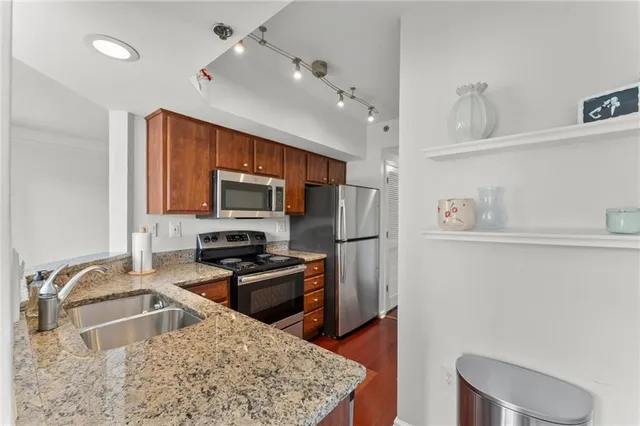 a kitchen with stainless steel appliances granite countertop a sink refrigerator and microwave