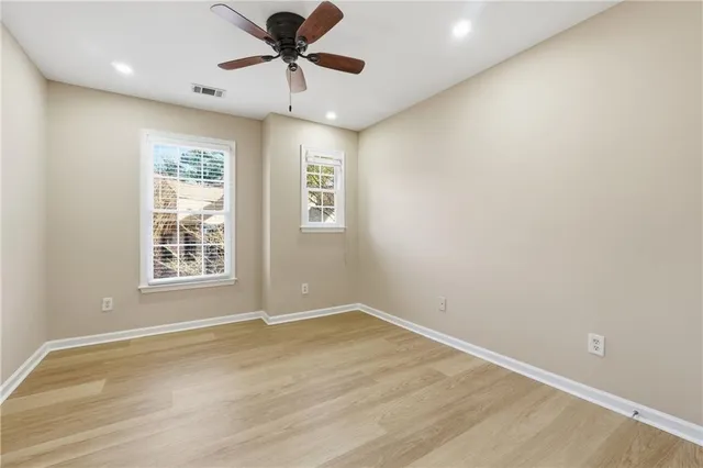 an empty room with a window and a ceiling fan