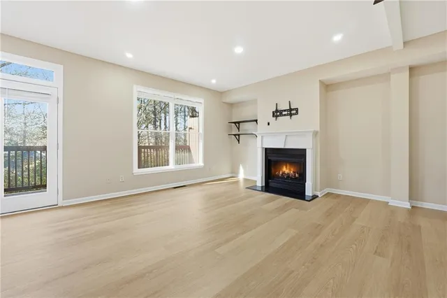 a view of an empty room with a window and fireplace