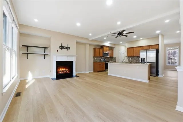 a view of a kitchen with a sink a fireplace and a window