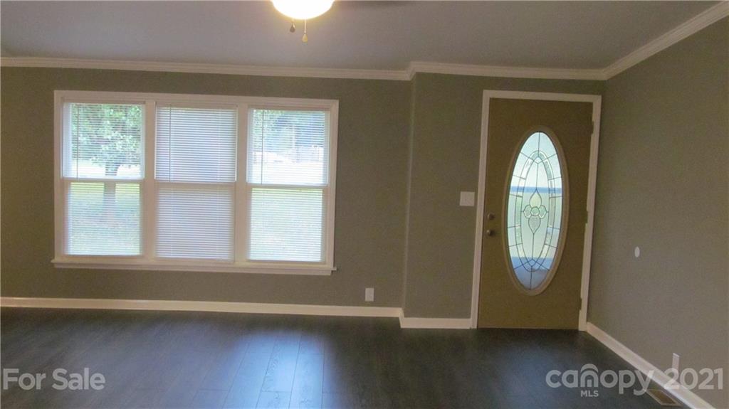 2896 Elbow Road Newton, NC 28658 - Photo 3 of 25 an empty room with wooden floor windows and glass door