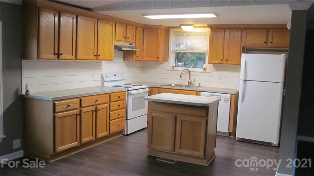 2896 Elbow Road Newton, NC 28658 - Photo 7 of 25 a kitchen with stainless steel appliances granite countertop a refrigerator a sink dishwasher and wooden cabinets with wooden floor