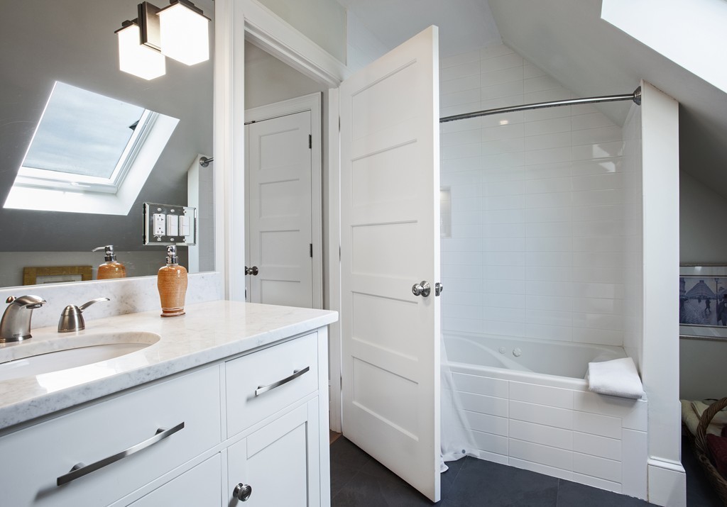 69 University Road, Unit 2 Brookline, MA 02445 - Photo 28 of 29 a bathroom with a shower sink and mirror