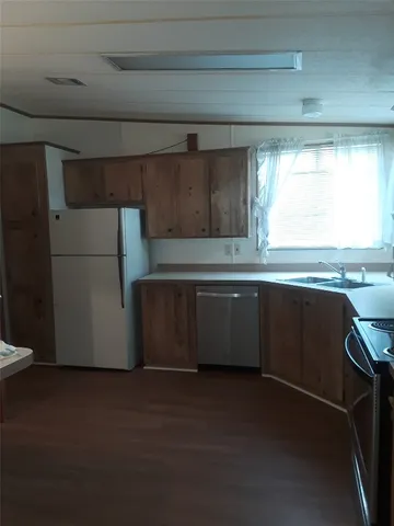 a kitchen with granite countertop a sink a window stainless steel appliances and cabinets