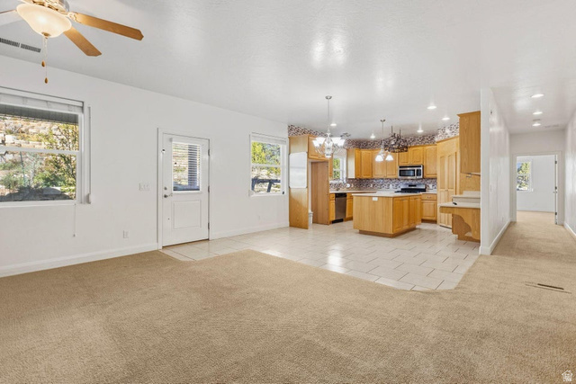1001 Pine Valley Road Pine Valley, UT 84781 - Photo 10 of 49 Kitchen featuring light colored carpet, a kitchen island, light tile patterned floors, and hanging lights