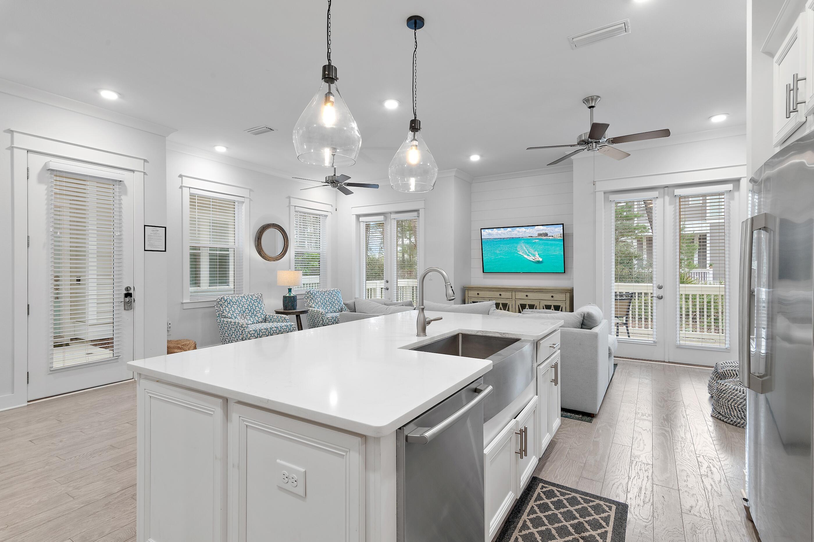 a large kitchen with a large counter top space a sink stainless steel appliances and cabinets