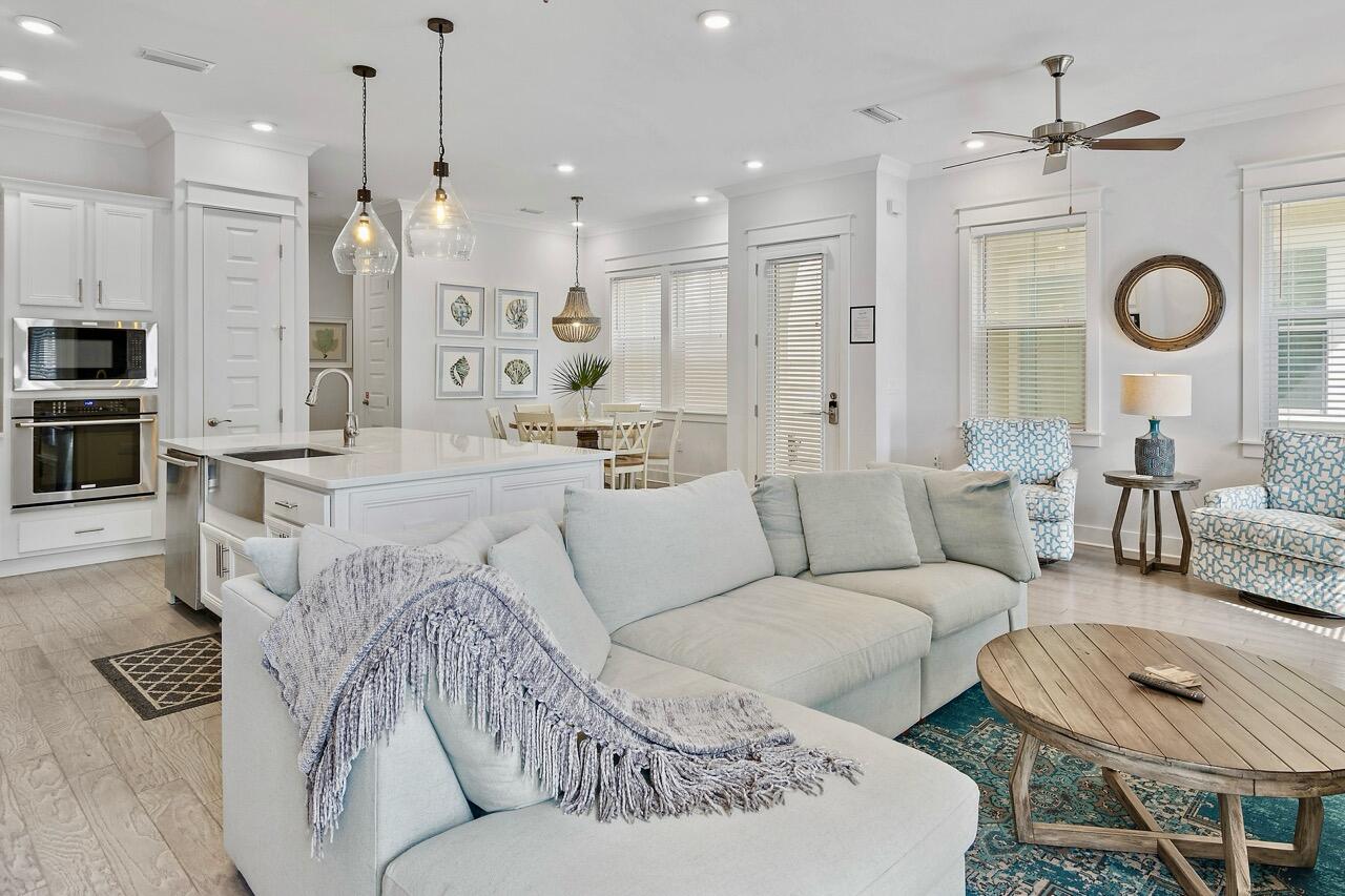 38 Pine Lands Loop East, Unit A Inlet Beach, FL 32461 - Photo 2 of 25 a living room with furniture kitchen view and a chandelier
