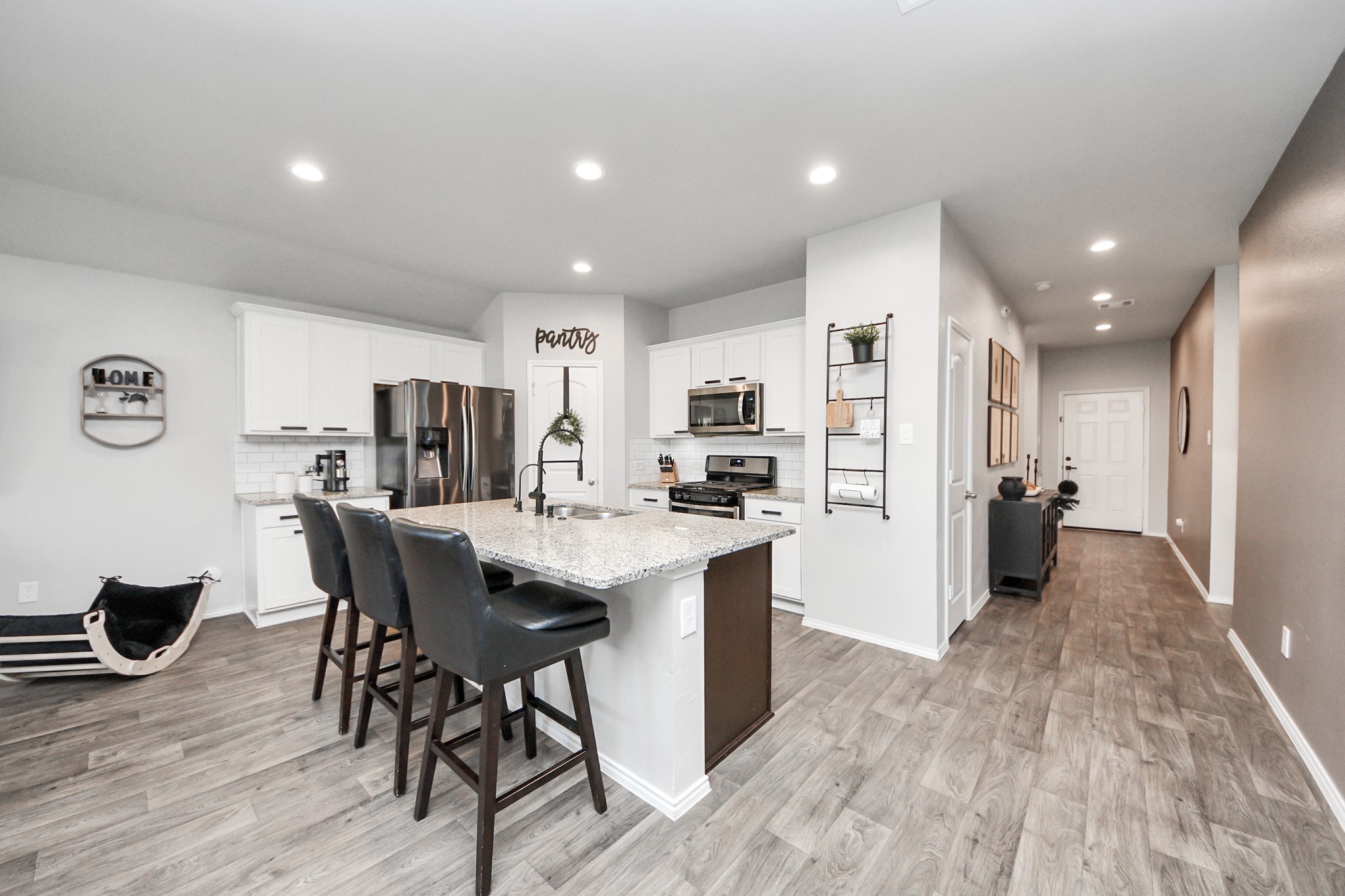 4315 Nervesa Dr. Katy, TX 77449 - Photo 16 of 41 a kitchen with stainless steel appliances kitchen island granite countertop a refrigerator a stove a sink a dining table and chairs with wooden floor