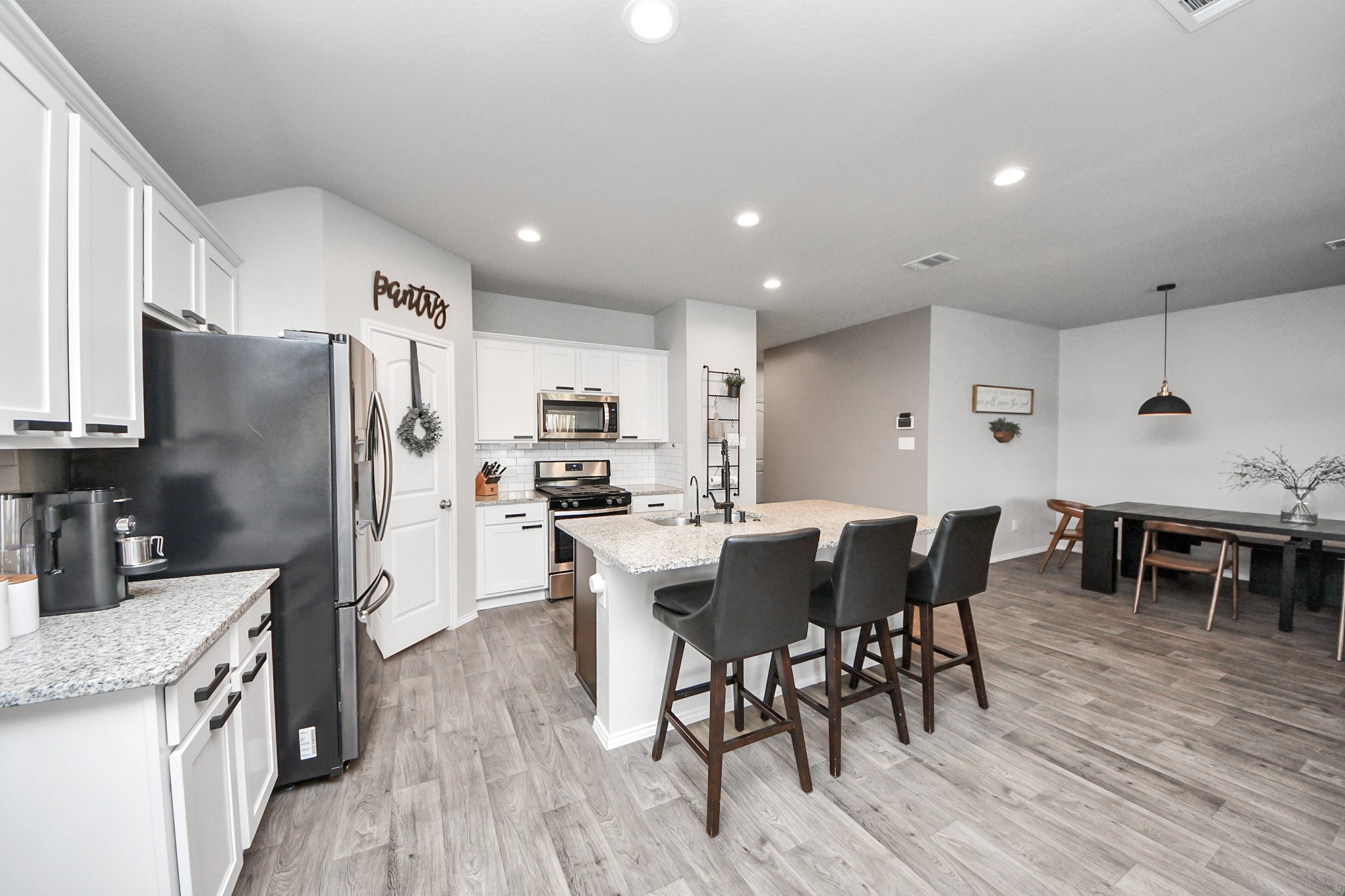 4315 Nervesa Dr. Katy, TX 77449 - Photo 18 of 41 a kitchen with stainless steel appliances kitchen island granite countertop a table chairs and a refrigerator