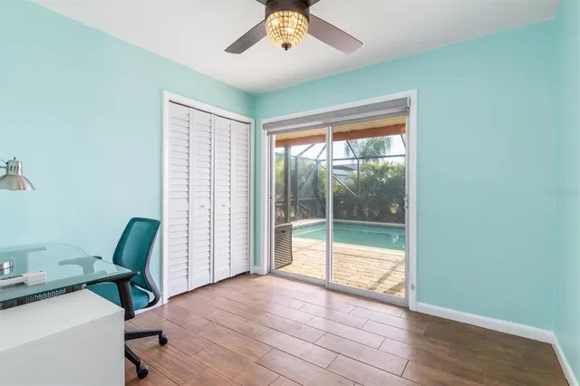 an empty room with wooden floor fan and a window