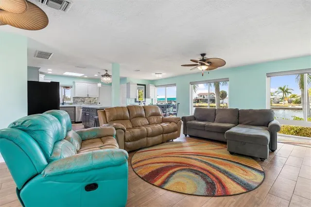 a living room with furniture kitchen view and a chandelier