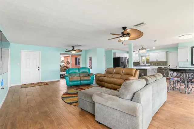 a living room with furniture kitchen view and a flat screen tv