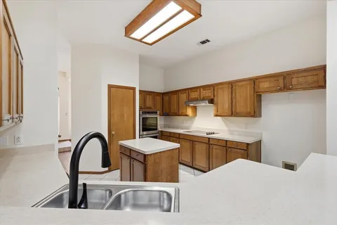a kitchen with stainless steel appliances kitchen island granite countertop a sink and cabinets