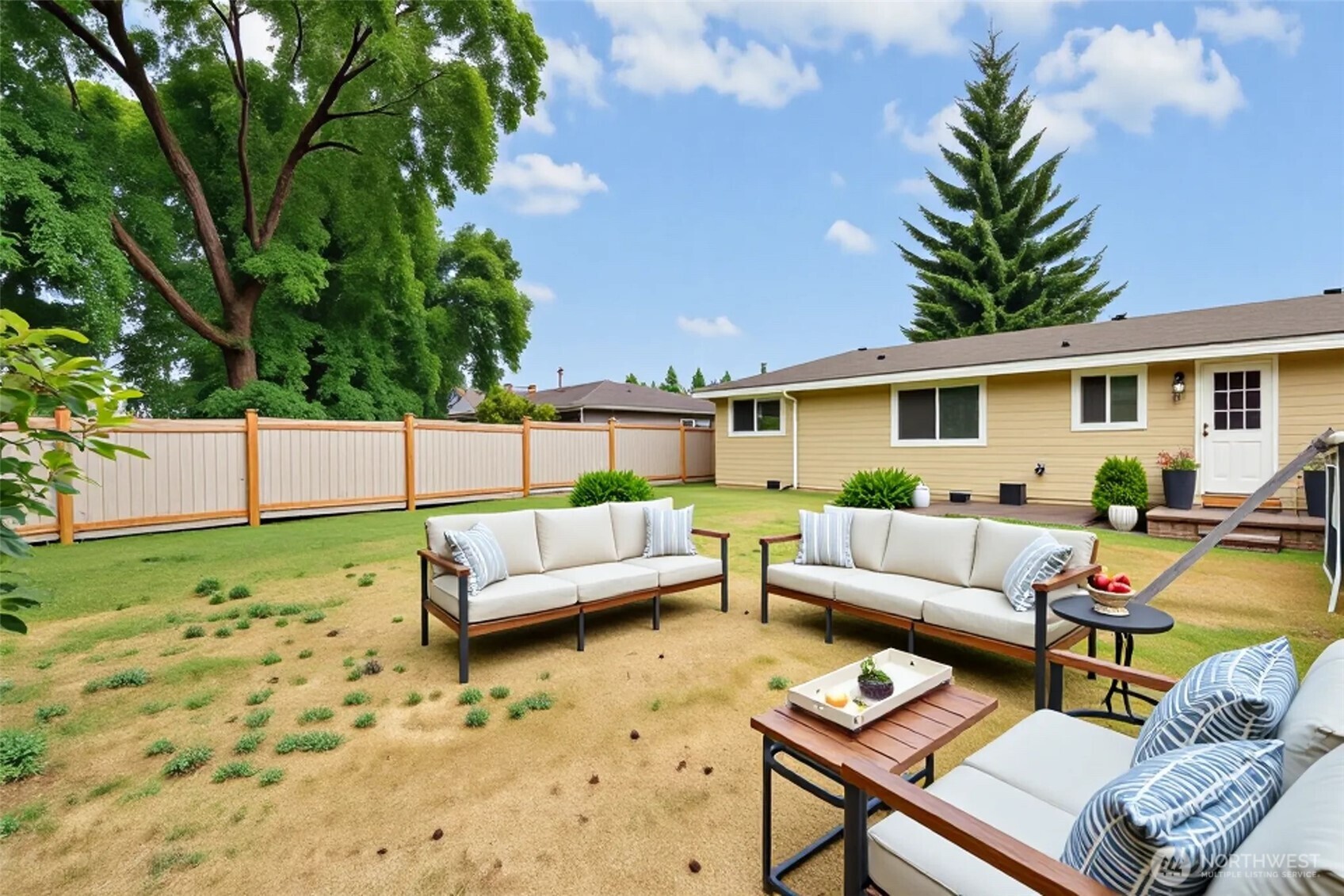 712 Alder Street Sultan, WA 98294 - Photo 8 of 8 a view of a patio with couches table and chairs with potted plants and large tree