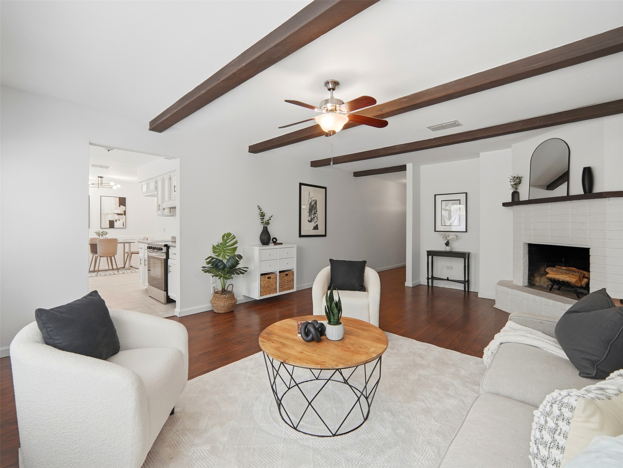 7001 Windrift Way Austin, TX 78745 - Photo 4 of 17 Rich hardwood floors and exposed ceiling beams define this inviting living area, centered around a cozy fireplace.