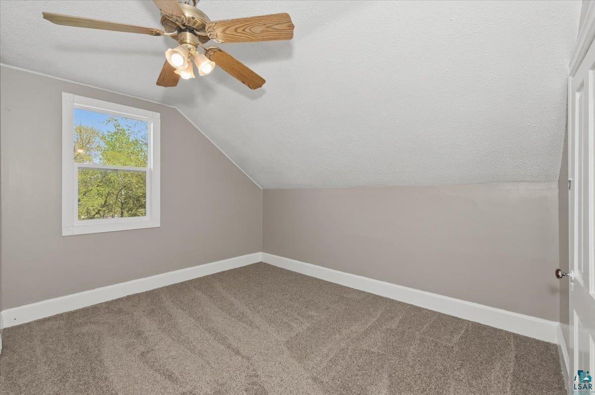 5319 East 3rd Street Superior, WI 54880 - Photo 26 of 33 Room featuring neutral carpeting, light gray walls, a window with white trim, a ceiling fan with integrated lighting, and a white paneled door