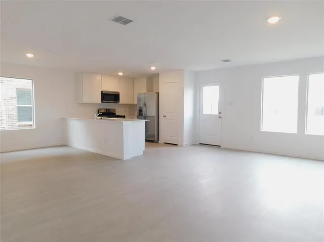 a view of a kitchen with a sink a microwave and cabinets