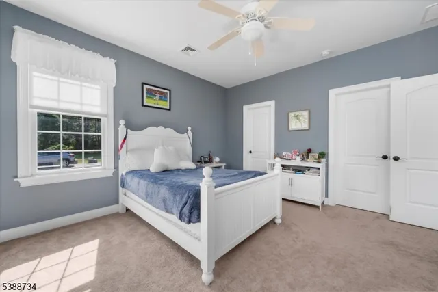 an empty room with windows and ceiling fan