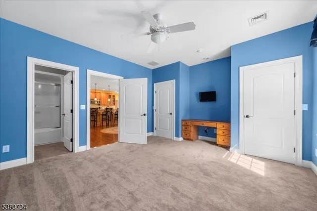 a open kitchen with stainless steel appliances granite countertop a stove top oven a sink a dining table and chairs with wooden floor