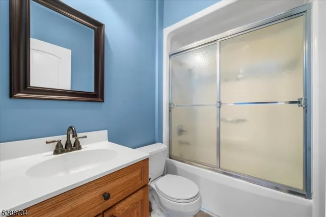 an open kitchen with wooden floor and a dining table