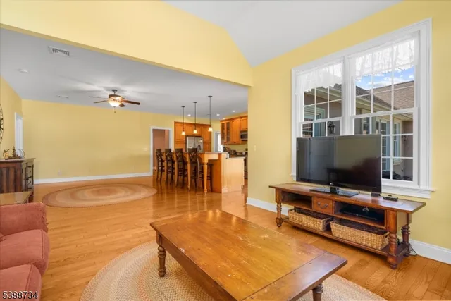 a large kitchen with stainless steel appliances kitchen island granite countertop a sink a stove and a wooden floors