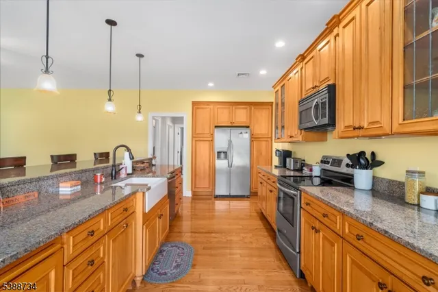 a open kitchen with granite countertop a stove top oven a sink a dining table and chairs