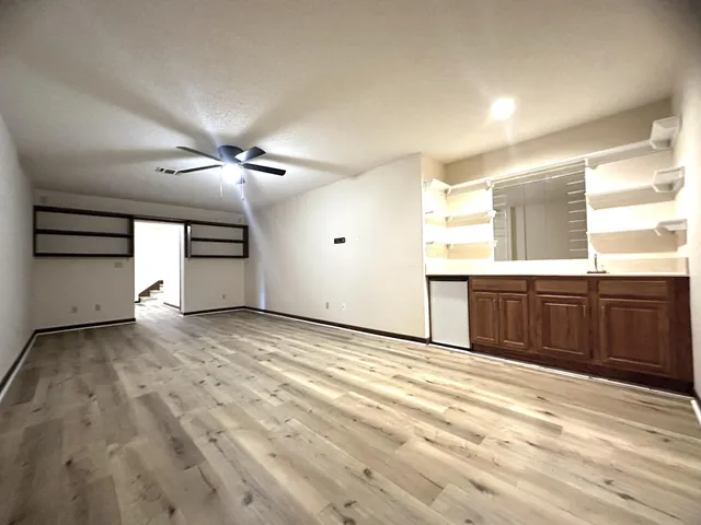a view of empty room with wooden floor
