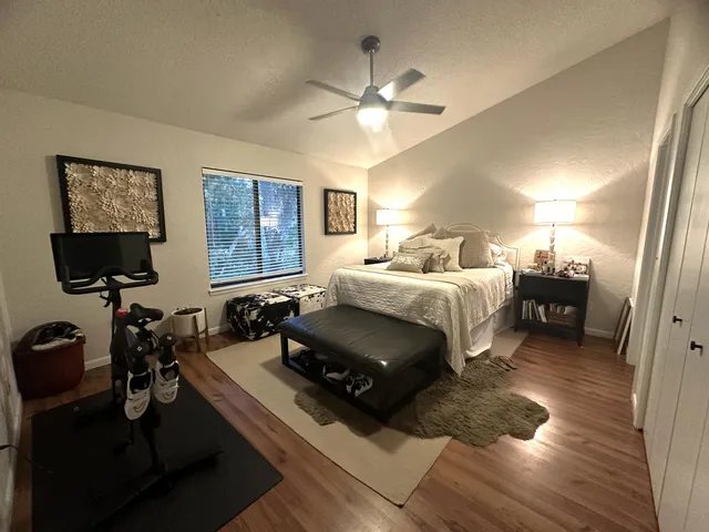 a view of empty room with wooden floor and fan