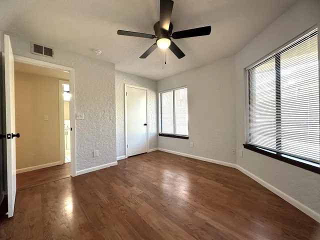 a view of empty room with wooden floor