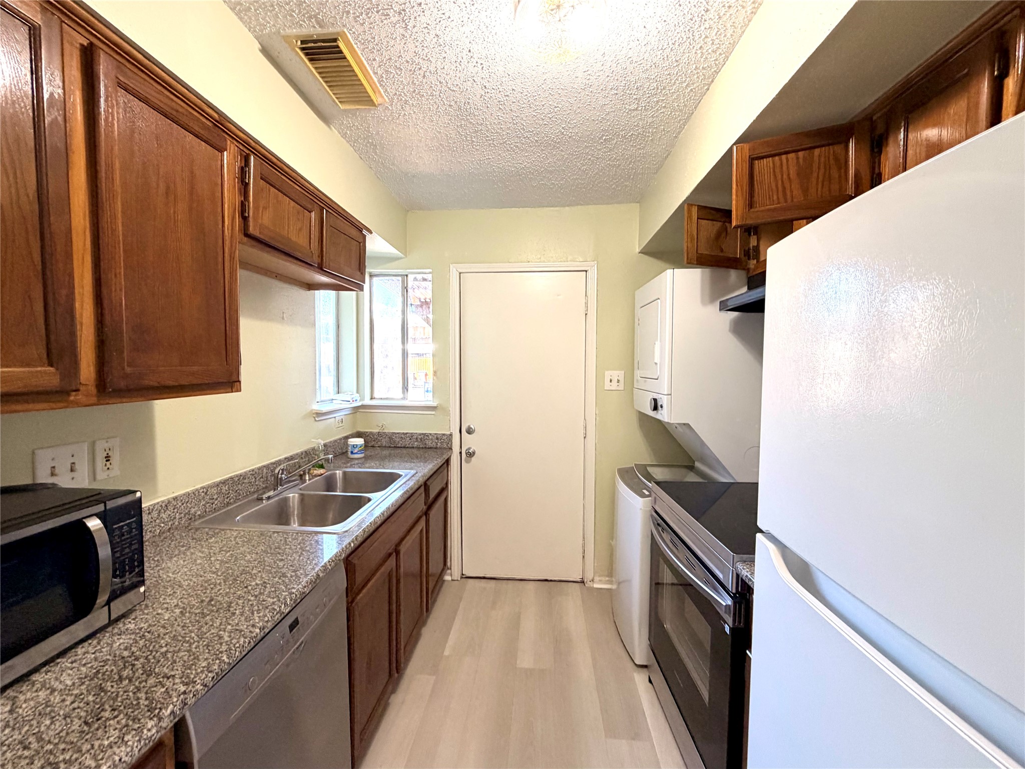 7789 Cook Road Houston, TX 77072 - Photo 8 of 18 a kitchen with granite countertop a sink stove and refrigerator